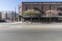 an old brick building with a car parked on the street in front of it is a commercial area next to the large warehouse