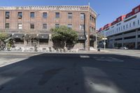 an old brick building with a car parked on the street in front of it is a commercial area next to the large warehouse