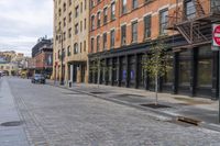 an old brick sidewalk and street next to buildings and a fire hydrant in the middle