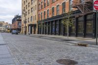 an old brick sidewalk and street next to buildings and a fire hydrant in the middle