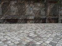 an old brick wall with a blue sign on the back of it in the middle of a paved street