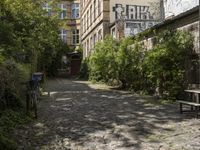 the cobblestones in the courtyard of this old building are lined with trees and bushes