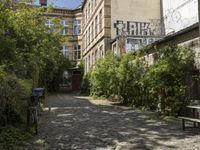 the cobblestones in the courtyard of this old building are lined with trees and bushes