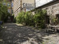 the cobblestones in the courtyard of this old building are lined with trees and bushes