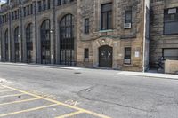 a very old building next to a parking lot with no cars or people in the street