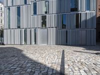 a brick street that has some cars in it and a building made out of aluminum foil