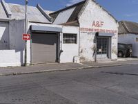 this is an old factory with an arrow sign next to it and some buildings on both sides