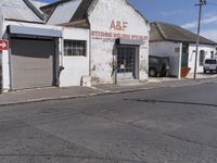 this is an old factory with an arrow sign next to it and some buildings on both sides