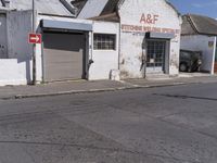 this is an old factory with an arrow sign next to it and some buildings on both sides