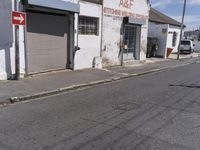 this is an old factory with an arrow sign next to it and some buildings on both sides