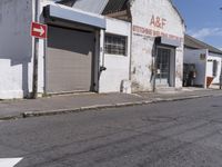 this is an old factory with an arrow sign next to it and some buildings on both sides