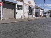 this is an old factory with an arrow sign next to it and some buildings on both sides