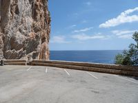 this is an old parking lot near a cliff with the ocean in the background and blue sky above