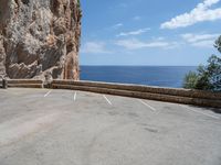 this is an old parking lot near a cliff with the ocean in the background and blue sky above