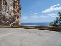 this is an old parking lot near a cliff with the ocean in the background and blue sky above