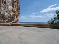 this is an old parking lot near a cliff with the ocean in the background and blue sky above