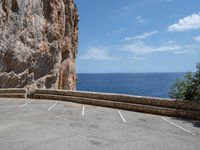 this is an old parking lot near a cliff with the ocean in the background and blue sky above