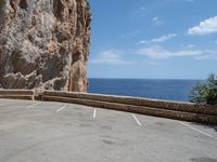 this is an old parking lot near a cliff with the ocean in the background and blue sky above