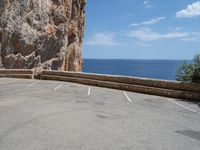 this is an old parking lot near a cliff with the ocean in the background and blue sky above