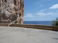 this is an old parking lot near a cliff with the ocean in the background and blue sky above