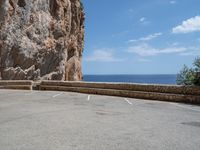 this is an old parking lot near a cliff with the ocean in the background and blue sky above