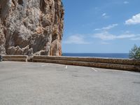 this is an old parking lot near a cliff with the ocean in the background and blue sky above