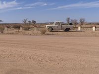 an old pickup truck sitting in a desert field with no one around it or there is a car