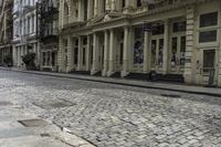 an old stone road with a bicycle parked on the sidewalk and an older building in the background