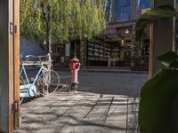 a small, old fashioned fire hydrant in the foreground by a building with books and bicycles parked in it