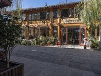 an open area on a chinese building with pots of trees and plants outside and inside