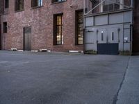 an old factory building with a broken sign in the middle of the street and a blue car parked behind the entrance