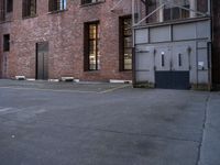 an old factory building with a broken sign in the middle of the street and a blue car parked behind the entrance