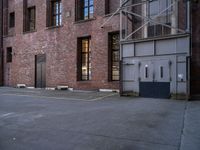 an old factory building with a broken sign in the middle of the street and a blue car parked behind the entrance