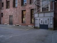 an old factory building with a broken sign in the middle of the street and a blue car parked behind the entrance