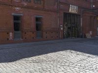 an older bricked walkway leads to a book store on the other side of the road