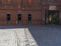 an older bricked walkway leads to a book store on the other side of the road