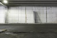 a broken toilet in the middle of an empty parking garage with concrete walls and cement floor