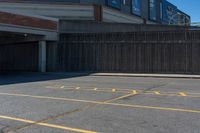 a parking lot with the words do not enter painted on it and some wood fence