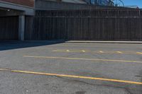 a empty parking lot with a yellow stop sign in front of a building and some other buildings