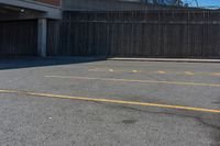 a empty parking lot with a yellow stop sign in front of a building and some other buildings