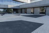 a view of an outside area of an office building with large windows and a circular driveway