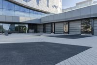 a view of an outside area of an office building with large windows and a circular driveway