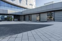 a view of an outside area of an office building with large windows and a circular driveway