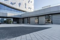 a view of an outside area of an office building with large windows and a circular driveway