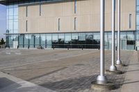 a parking meter is in front of a building with glass walls and columns on the side