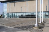 a parking meter is in front of a building with glass walls and columns on the side