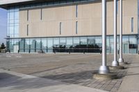 a parking meter is in front of a building with glass walls and columns on the side