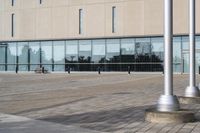 a parking meter is in front of a building with glass walls and columns on the side