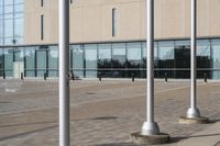 a parking meter is in front of a building with glass walls and columns on the side