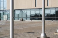 a parking meter is in front of a building with glass walls and columns on the side